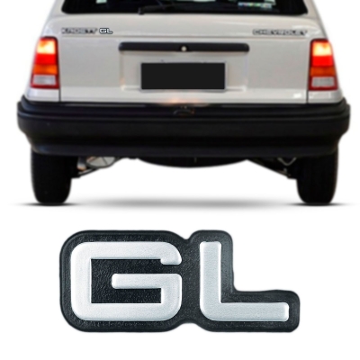 Emblema 'GL' - Chevrolet Kadett / Monza / Ipanema 1991/1996 - Cinza / Fundo Preto