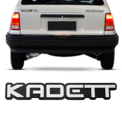 Emblema 'KADETT' - Chevrolet Kadett 1991/1996 - Cinza / Fundo Preto